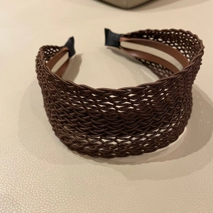 Close-up of brown woven bohemian headband showing intricate fiber texture and lining