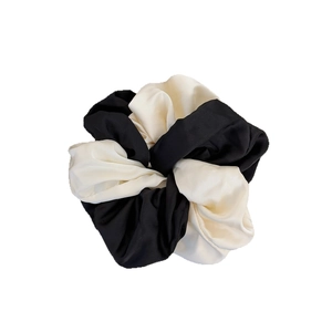 Elegant black and white contrast satin scrunchie with a glossy finish for hair styling