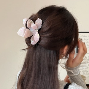 Pince à cheveux fleurie en acétate rose pâle avec cristal portée par un mannequin