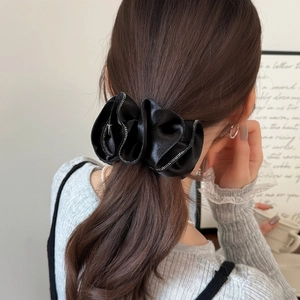 Chouchou élégant en satin plissé noir avec bordure perlée argentée porté sur modèle