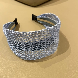 Detailed top view of light blue woven headband with intricate mesh pattern and protective tips