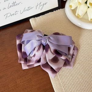 Détail de la pince à cheveux nœud violet tie-dye avec satin et décorations de perles