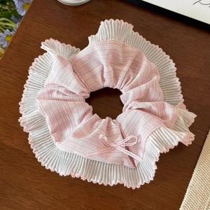 Détail d'un chouchou à carreaux roses avec dentelle de mousseline plissée et nœud