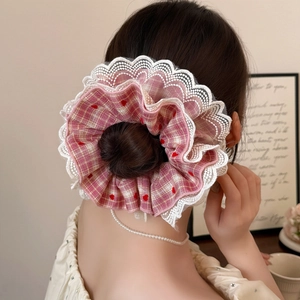 Pink plaid lace scrunchie with red hearts shown on a bun hairstyle for women