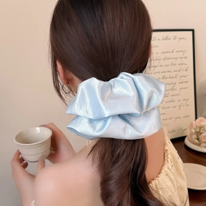 Eleganter hellblauer Satin-Haargummi mit Perlmuttglanz für Pferdeschwanz in Wohnambiente