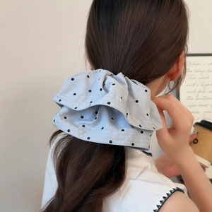 Nahaufnahme hellblau gepunkteter Stoff-Scrunchie mit doppelten Wellenkanten für Damen