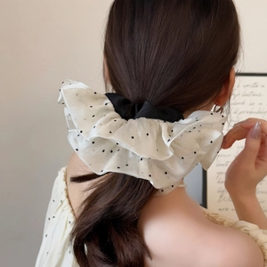 Oversized polka dot mesh scrunchie hair tie shown in a stylish low ponytail hairstyle
