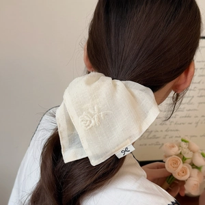 Elegant beige chiffon hair scrunchie with floral embroidery on a low ponytail