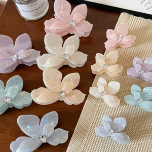 Détail de pinces à cheveux en acétate en forme de fleur avec strass et tons macaron