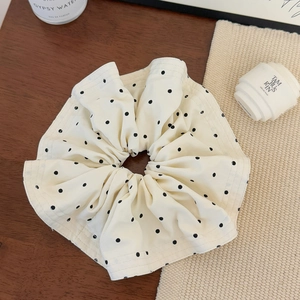 Detailansicht eines großen Haargummis mit Polka-Dots und weicher Faltenstruktur