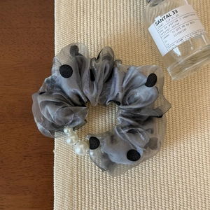 Gros plan sur le chouchou en organza gris à pois avec des perles artificielles élégantes