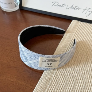 Gros plan du bandeau large à carreaux bleus et blancs avec étiquette sur table en bois
