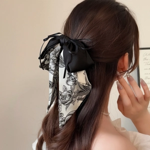 Elegante fermaglio per capelli con fiocco stile inchiostro e nastri su capelli mossi