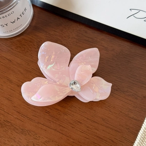 Détail de la pince à cheveux fleur en acétate rose nacré avec strass brillant
