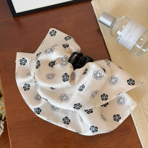 Détail d'une élégante pince à cheveux en tissu avec motif camélia noir