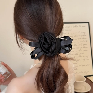 Elegant black silk mesh rose hair clip with bow decoration on a female model