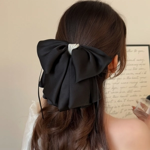Elegant black satin bow hair clip with decorative white pearls for a vintage hairstyle