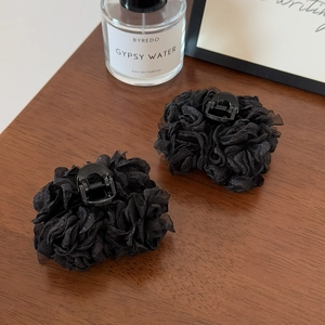 Détails de pinces à cheveux élégantes avec fleurs en tulle noir sur un fond en bois