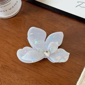 Détail macro de la pince à cheveux papillon en acétate iridescent avec cristal goutte