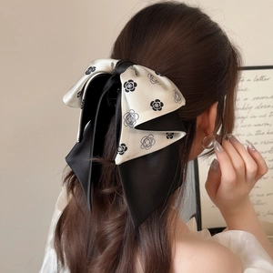 Elegant black and white camellia bow hair claw clip for a stylish ponytail back view