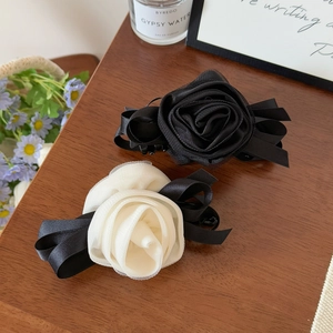 Elegant 3D mesh rose banana hair clip in black and white styles on wooden surface