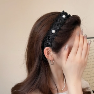 Serre-tête élégant en dentelle noire avec perles et nœud porté pour un style de luxe chic