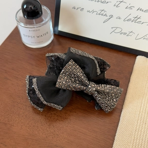 Detailed macro view of large black mesh bow hair claw clip with crystal embellishments