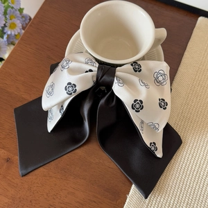 Detail view of the French style camellia bow hair claw on a white ceramic coffee cup