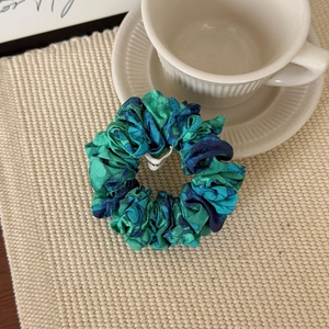Détail d'un chouchou à imprimé floral sur un tapis tissé au décor minimaliste