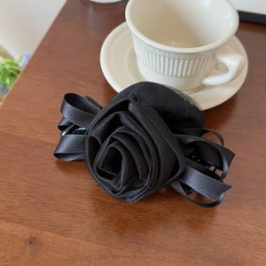 Detailed view of handcrafted black mesh rose hair clip with multilayered petals