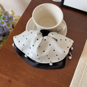 Détail d'un nœud papillon en satin à pois noirs avec bordure en perles blanches élégantes