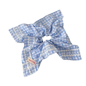 Chouchou à carreaux bleu et blanc avec bordure en dentelle et motifs de cœurs