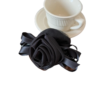 Elegant 3D mesh rose banana clip made of black satin ribbon on a white background