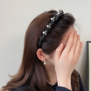 Serre-tête élégant en satin noir torsadé avec perles blanches et cristaux sur un modèle