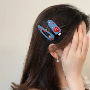Cute denim blue hair clips set with heart and cherry patterns on model side hair
