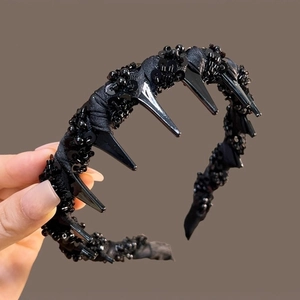 Detail of punk style black spiked headband with hand-sewn beads and non-slip inner teeth