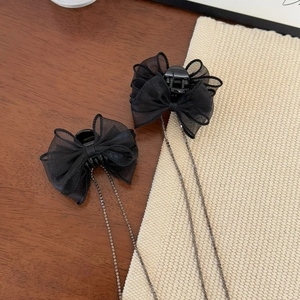 Detailed close-up of elegant black mesh bow hair clips with shimmering rhinestone chains