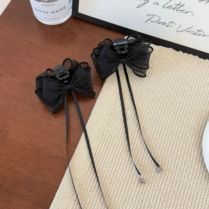 Detail of elegant black mesh bow hair claw clips with long ribbon tassels and beads