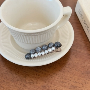Elegante fermaglio per capelli con perle marmorizzate e perle finte su tazza di ceramica