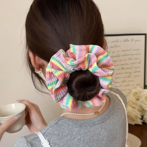 Detail of colorful striped fabric scrunchie with pleated texture on a hair bun
