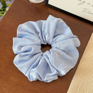 Gros plan d'un chouchou bleu clair à imprimé papillon sur une table en bois décorée