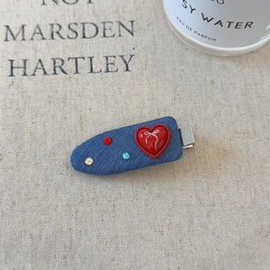 Detail of denim blue duckbill hair clip featuring red heart and sparkling rhinestones