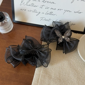 Détails des barrettes nœuds en maille noire avec papillons en strass scintillants