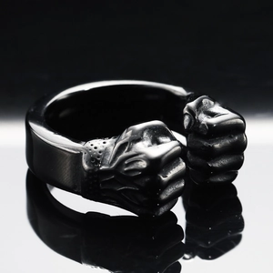 Détail de la bague en acier inoxydable noir avec deux poings sur un anneau ouvert