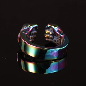 Gros plan d'une bague ouverte en acier titane irisé avec détails en forme de poing