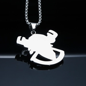Macro shot of polished stainless steel pirate skull pendant with box chain on black surface