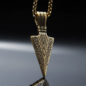 Vintage golden stainless steel arrowhead pendant with textured relief on a bead chain