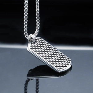 Vue macro d'un collier militaire en acier argenté avec motif de losanges gaufrés
