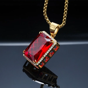 Vue macro d'un pendentif rubis rectangulaire avec bordure en cristal sur surface réfléchissante