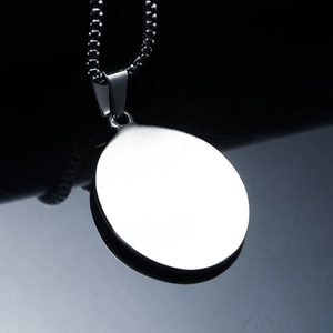 Polished silver stainless steel oval pendant necklace on a black reflective surface